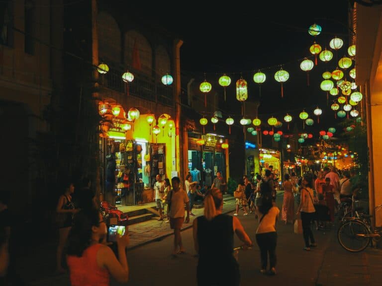 A bustling street scene at night, adorned with vibrant lanterns and filled with people. A bustling street scene at night, adorned with vibrant lanterns and filled with people.