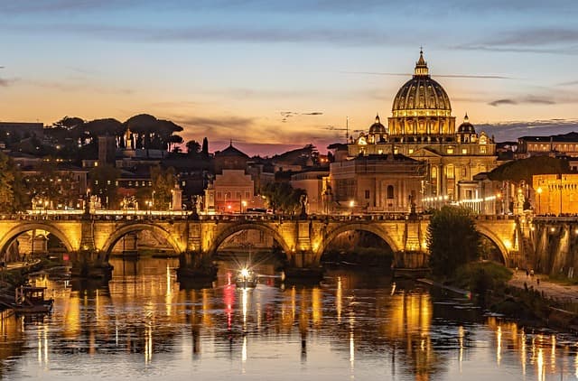 Evening view of St. Peter's Basilica and the Tiber River illuminated by sunset. Evening view of St. Peter's Basilica and the Tiber River illuminated by sunset.