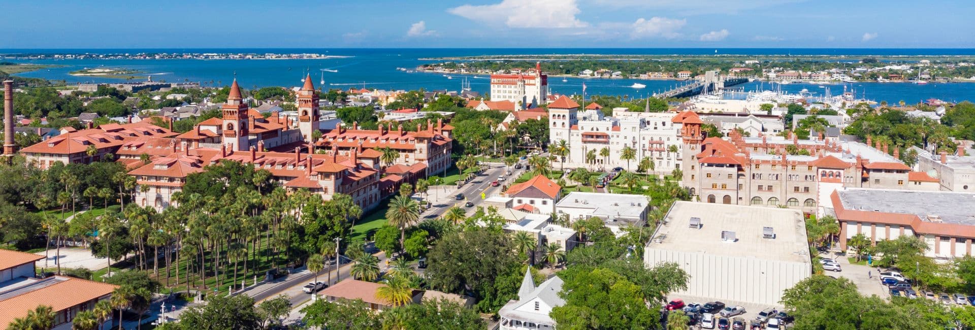 Aerial view of a coastal city featuring historic buildings and lush greenery.
